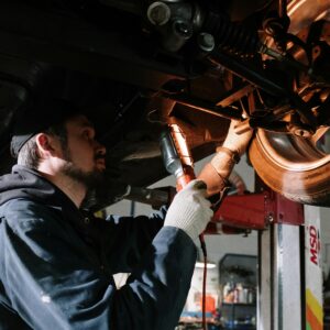 Man in Blue Dress Shirt Holding Red and Black Power Tool